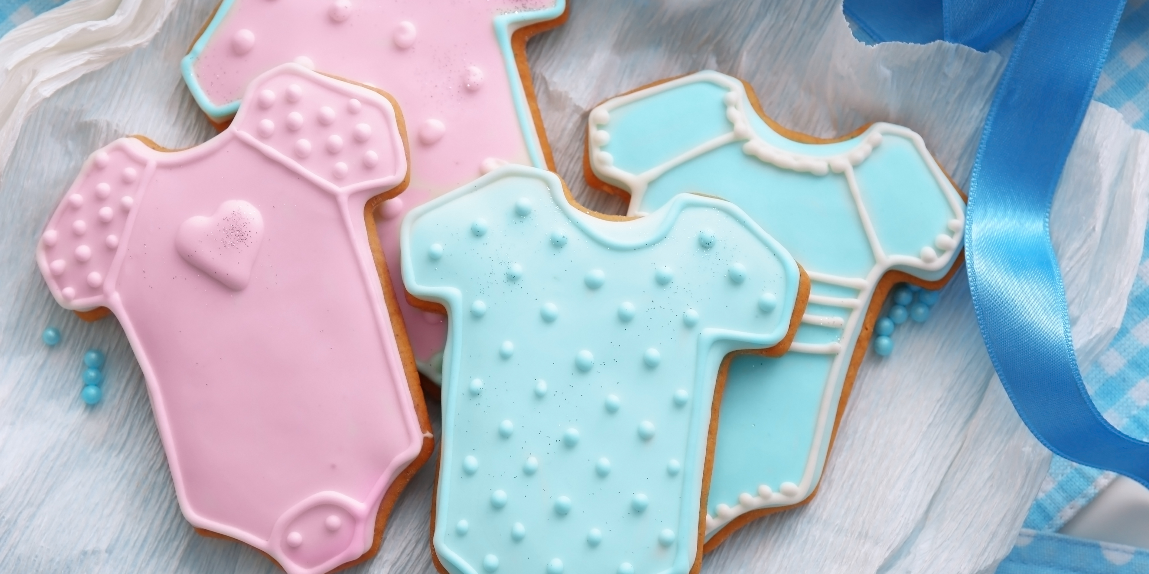 Cake shaped in pink and blue coloured onesies