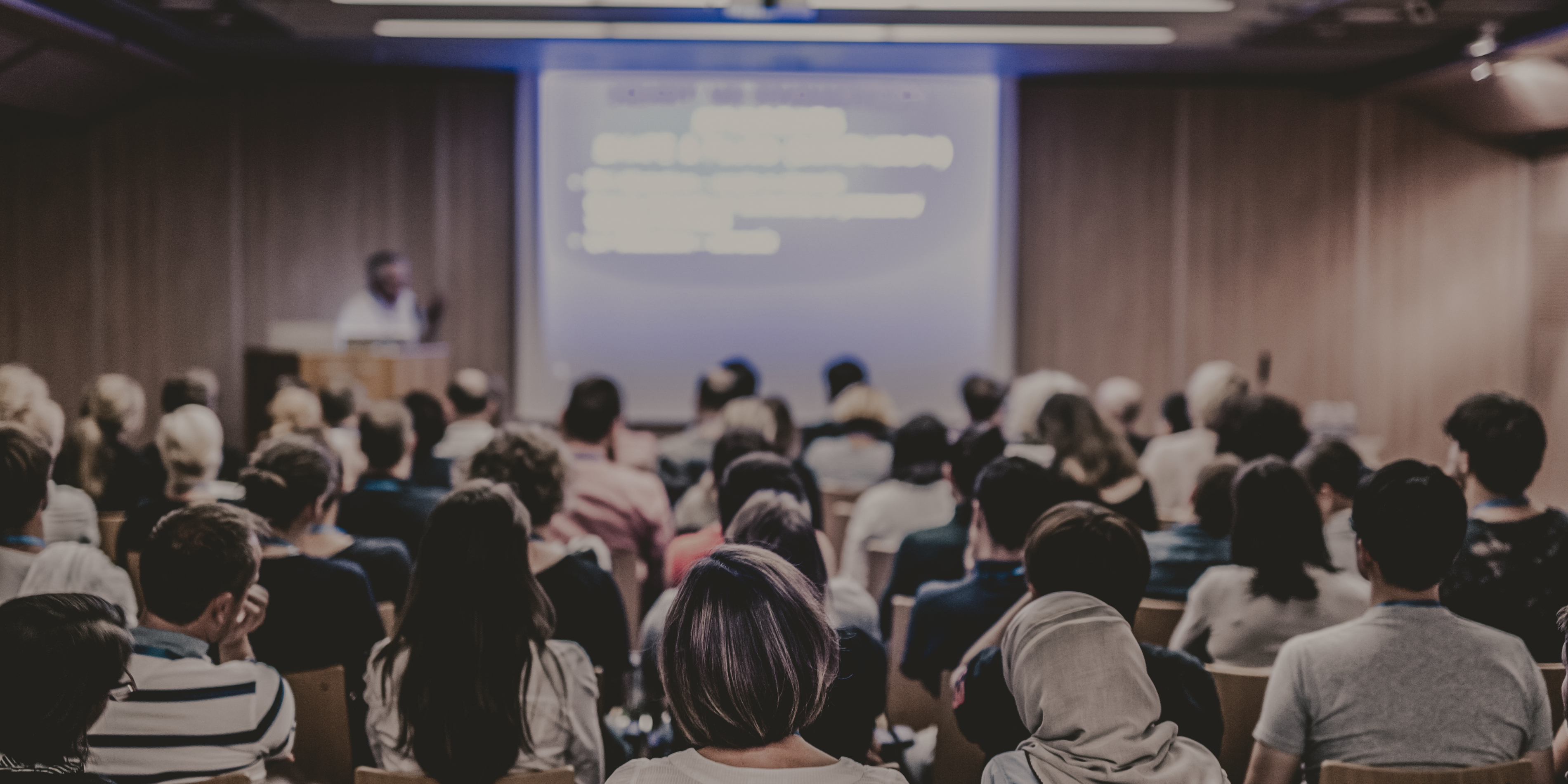 Photo of a conference taken from the back.