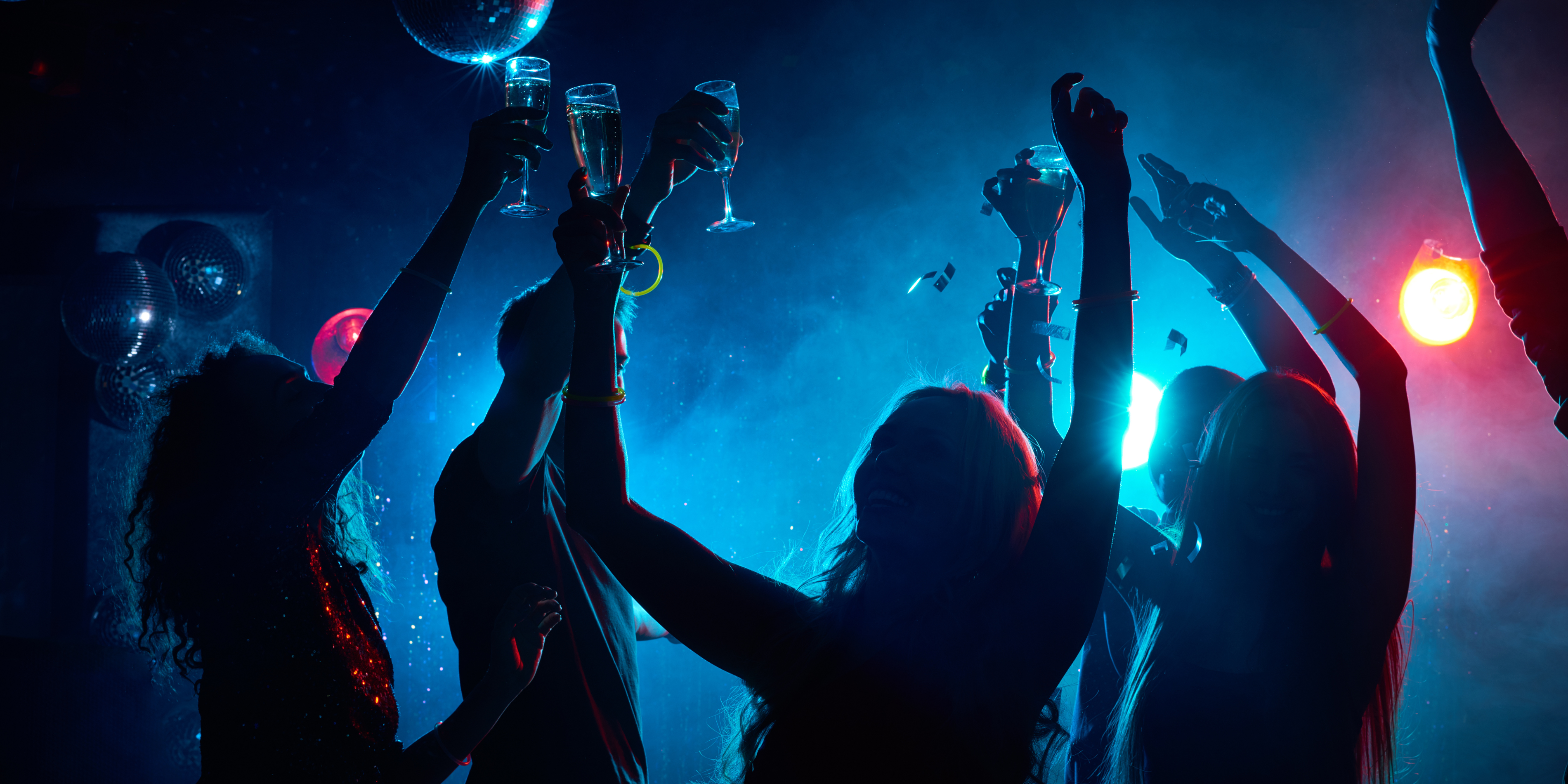 Group of people partying indoors under dark disco lights