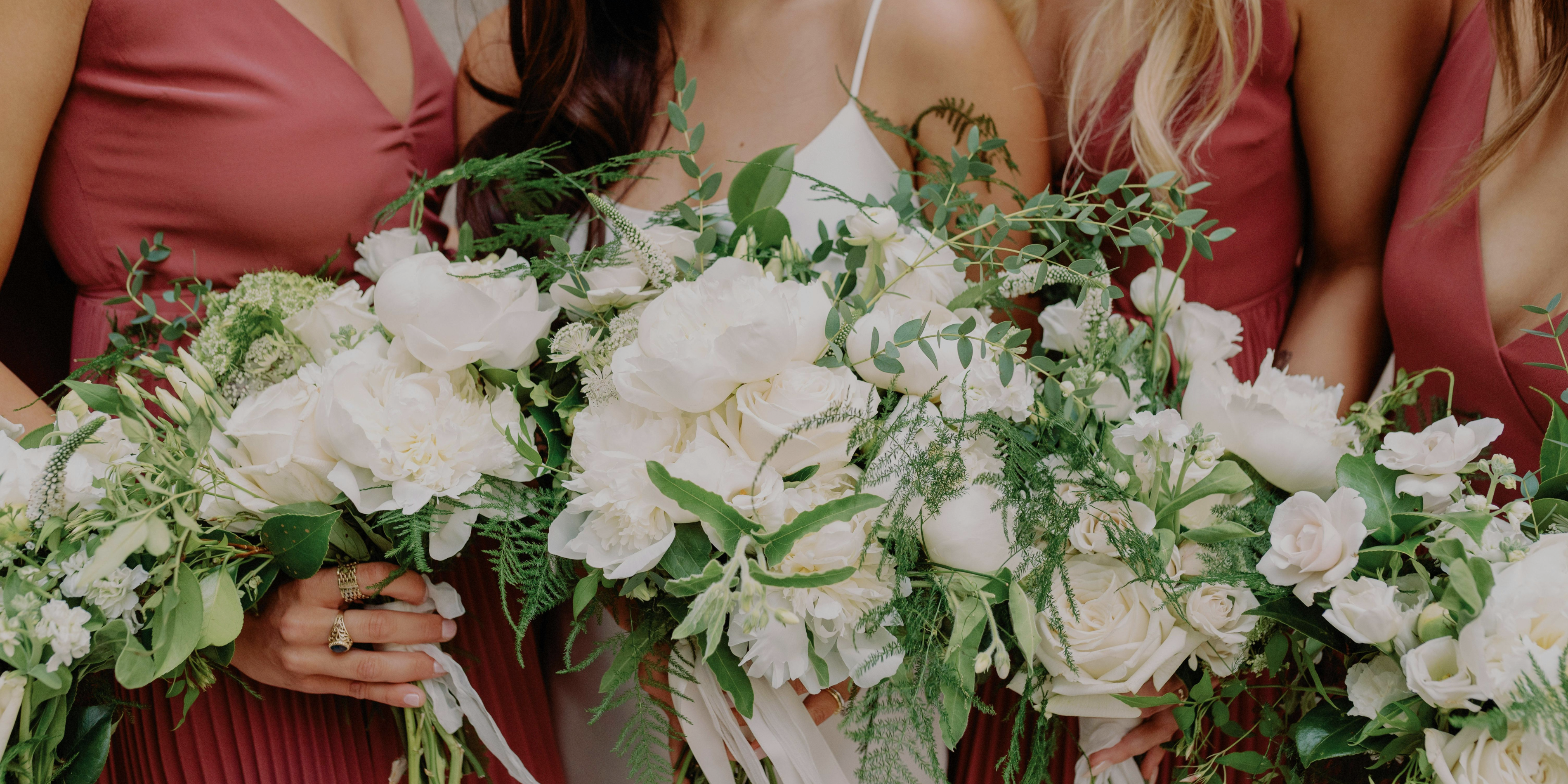 3 bridesmaid surrounding the bride holding white flower bouquet