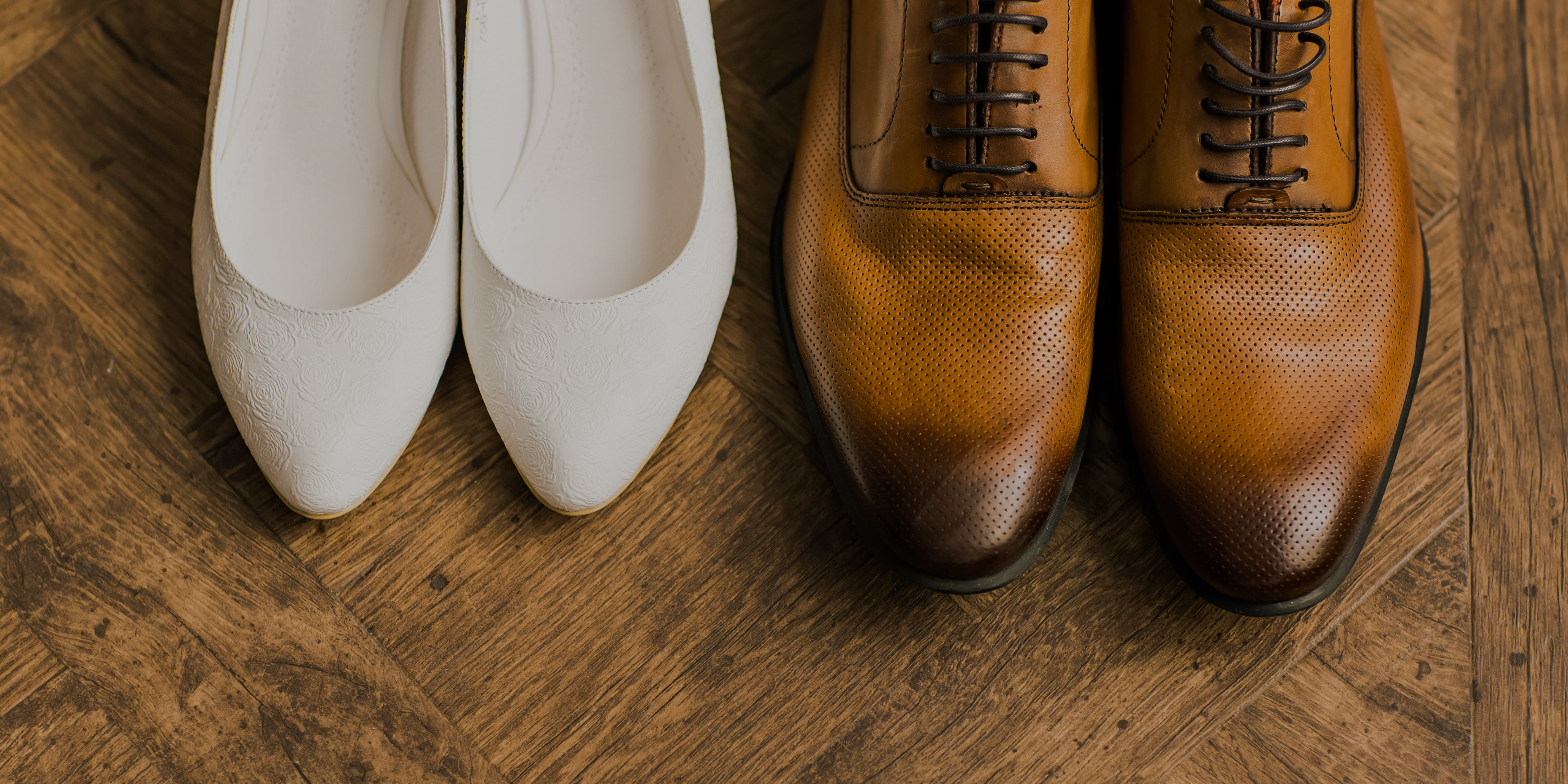 Groom's shoe next to bride's sandals
